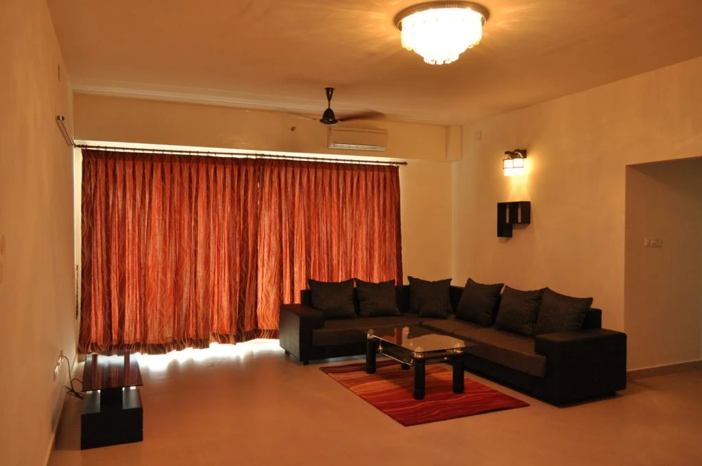 Furnished living room with an L-shaped sofa in an Estancia flat, Guduvanchery